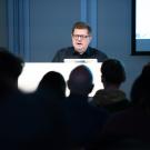 Artist Josiah McElheny at the podium foregrounded by audience
